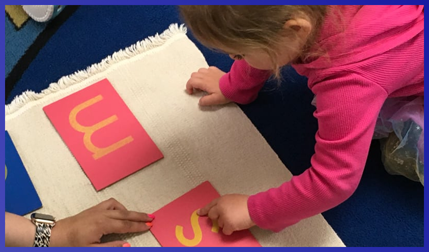 A young girl playing with letters