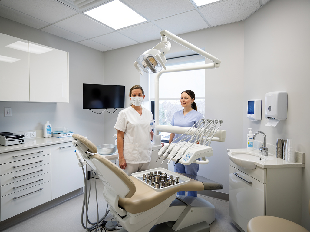 Consultorio dental moderno con dos profesionales de salud, silla odontológica y equipo clínico esterilizado