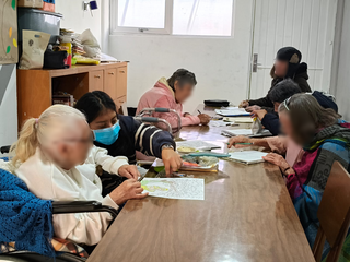 Grupo de personas mayores realizando actividades de dibujo y manualidades en una mesa
