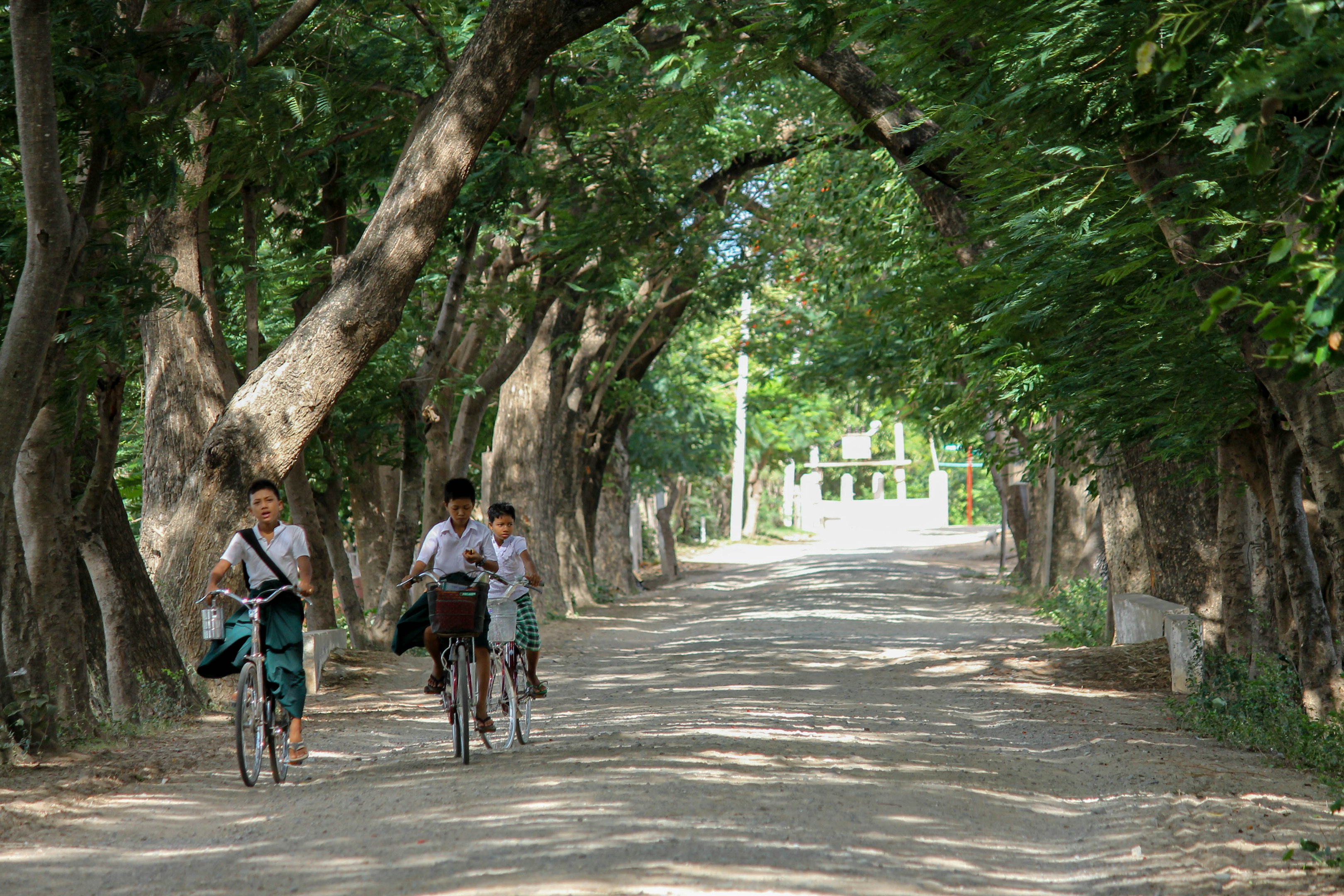Un par de personas montando bicicletas por un camino de tierra Un par de personas montando bicicletas por un camino de tierra