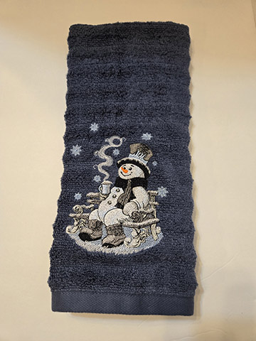 Dark blue hand towel with a snowman on a bench design