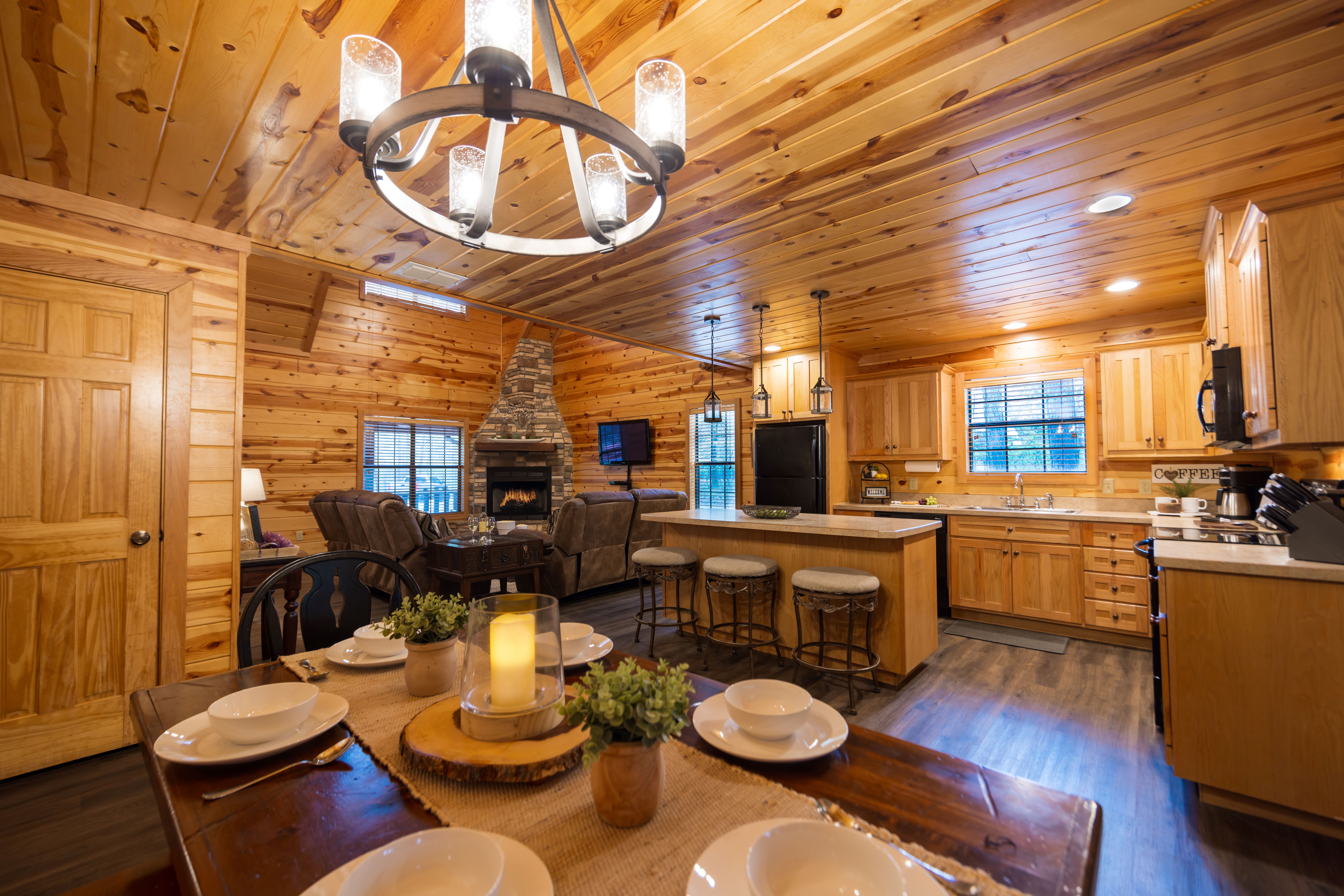 Rustic log cabin surrounded by tall pine trees in a forest setting.