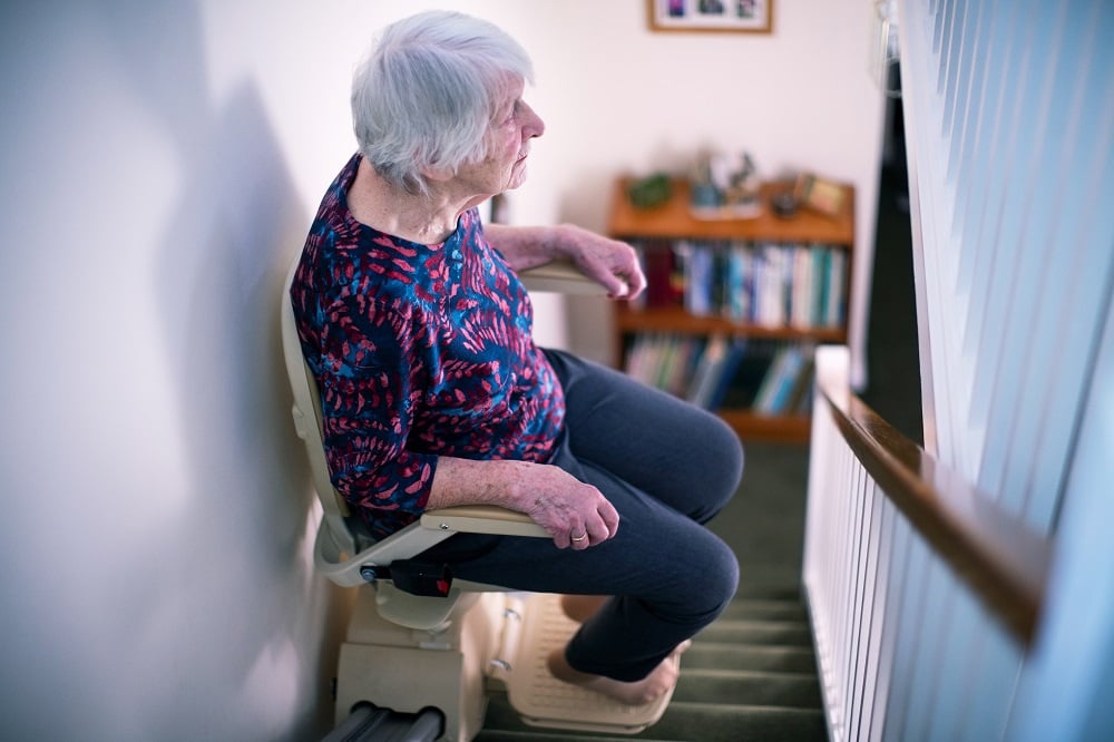 Woman going upstairs on stairlift