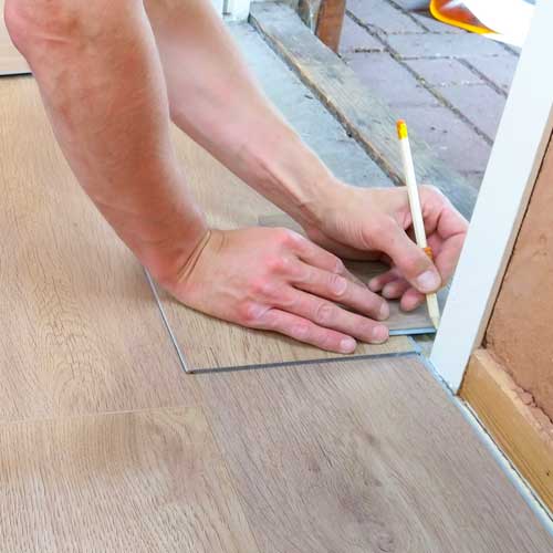 Worker Hands Installing Laminate Floor