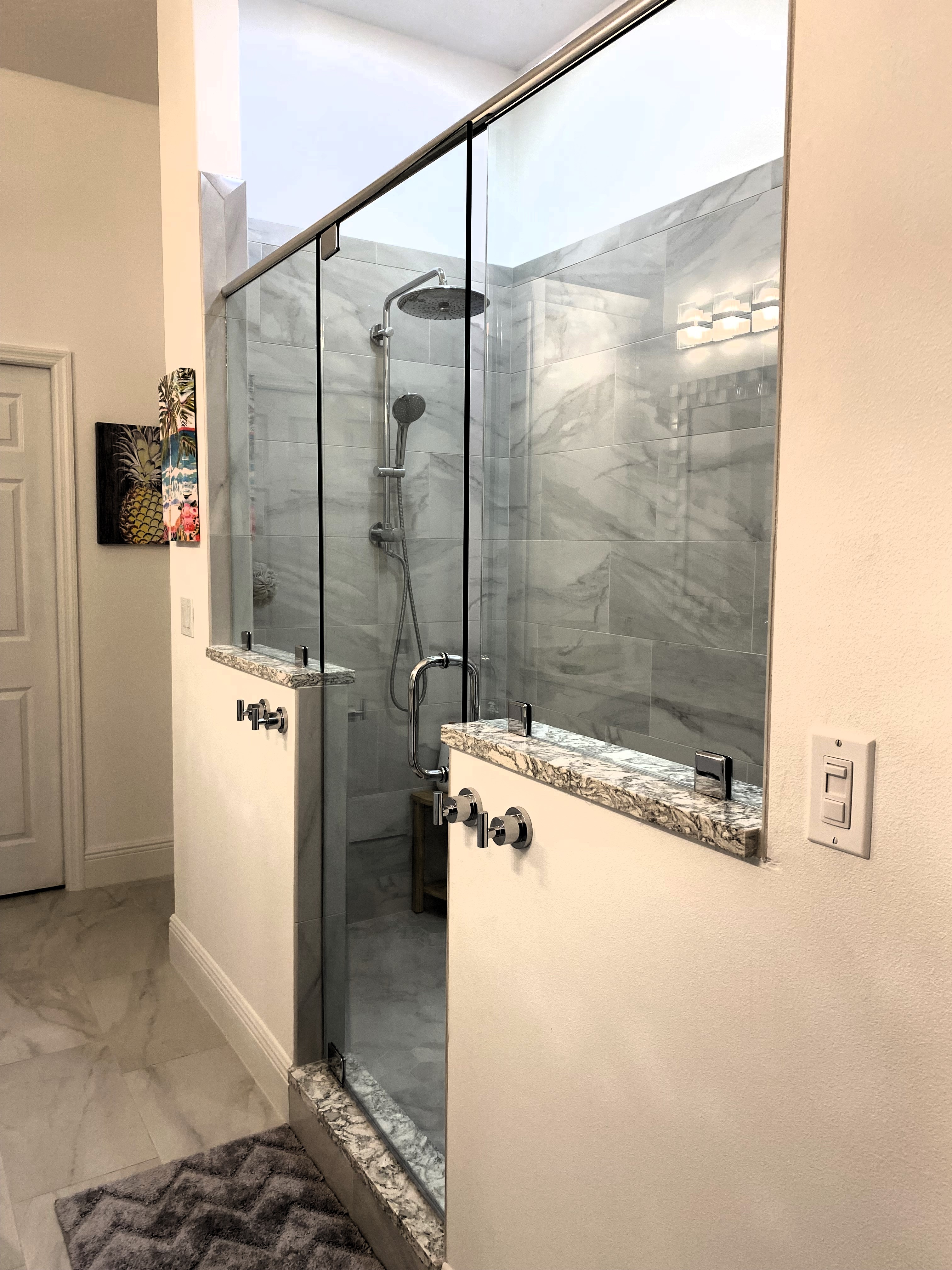 Stunning porcelain tiled shower with Cambria quartz shower caps and curb.