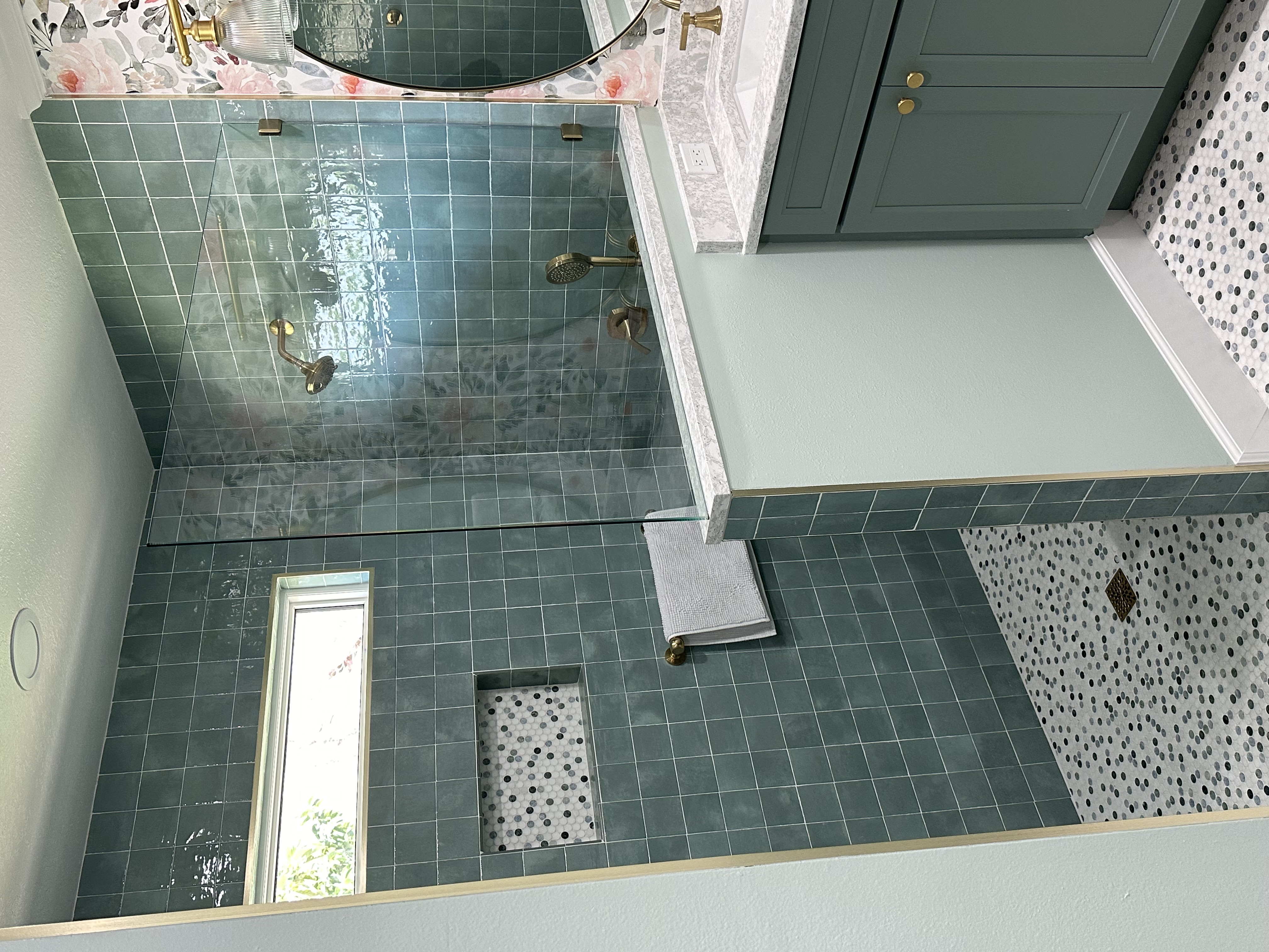 Beautiful and serene walk-in shower with 3/8" glass panel and gold shower fixtures. 