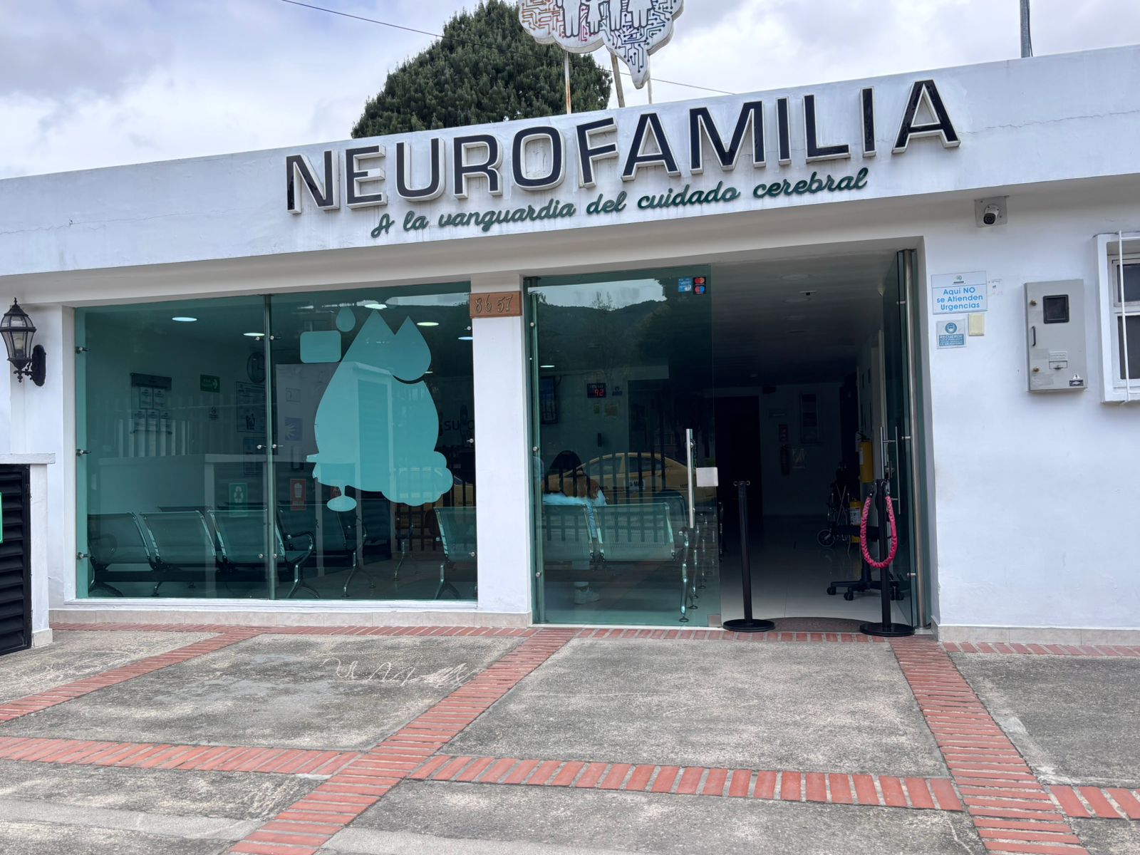 Fachada de la clínica Neurofamilia con puertas de vidrio y área de recepción visible.