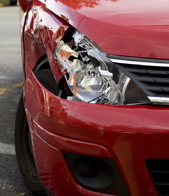 A red car with a damaged headlight after an accident