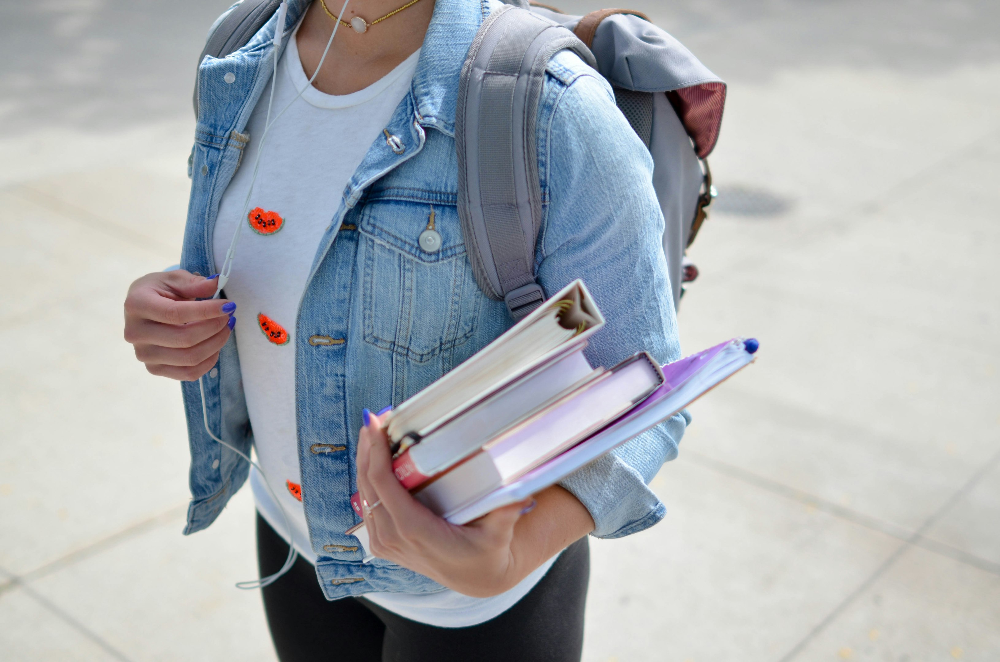 mujer con chaqueta de mezclilla azul sosteniendo un libro