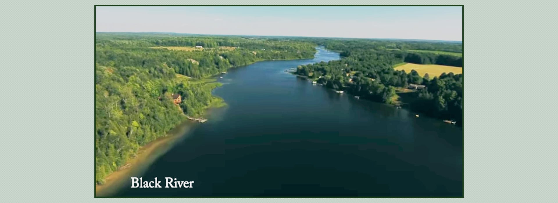 Aerial view of Black River flowing through lush green forested landscape.