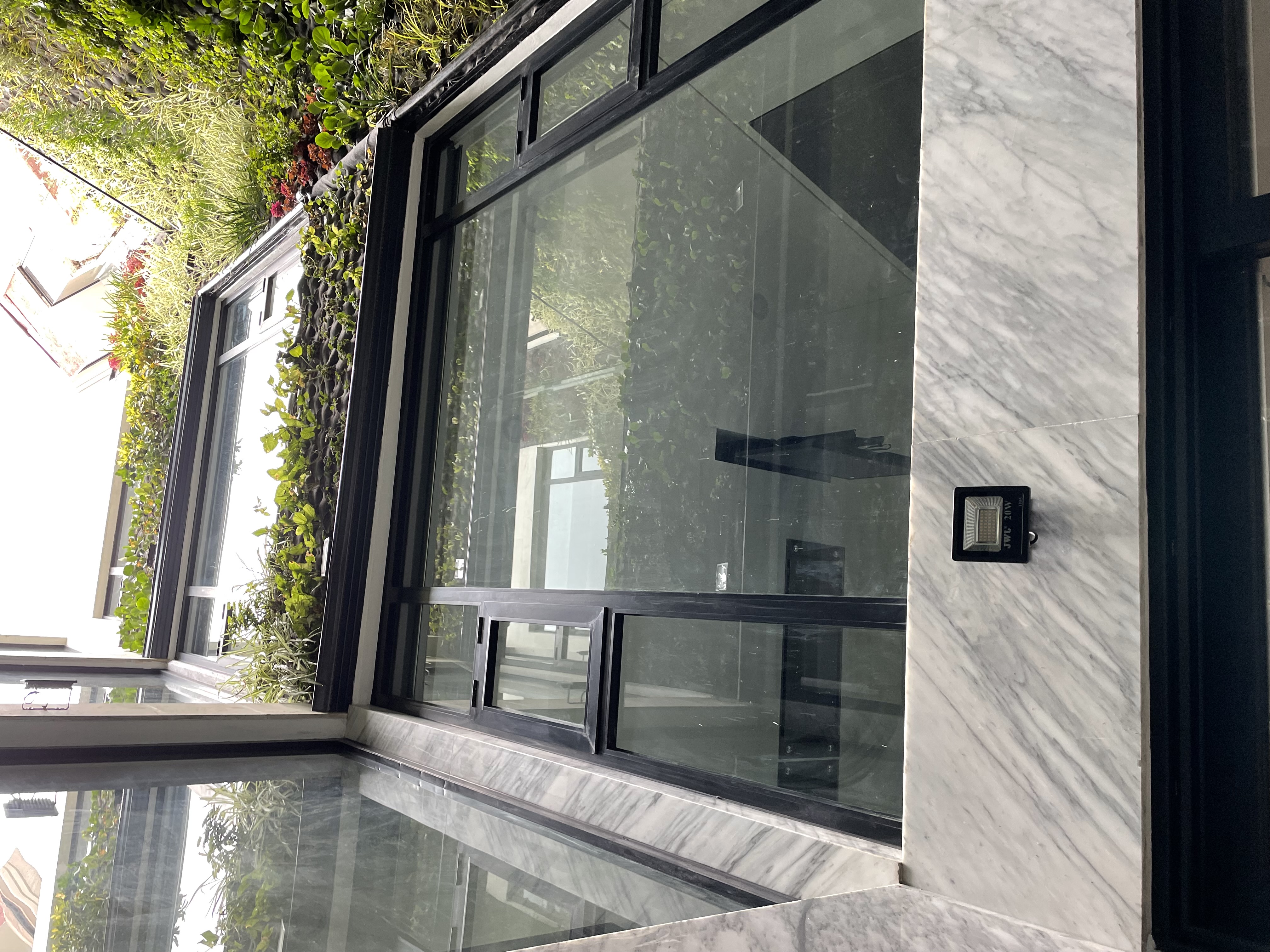 Modern indoor plant cultivation facility with advanced LED lighting, glass enclosures, and visible ventilation system.