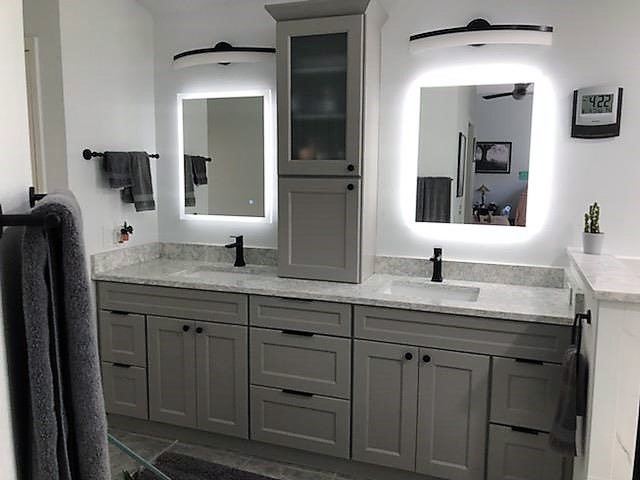 The back lit mirrors make the Cloud paint cabinetry and matte black hardware pop on this large vanity.
