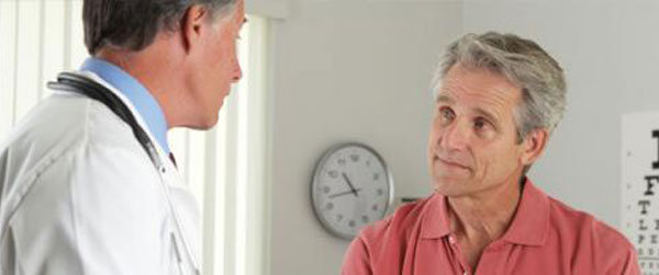 Senior doctor asking elderly patient questions