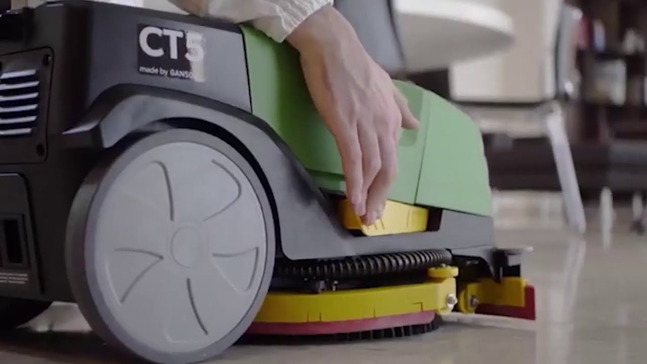 Máquina fregadora de suelos CT5 con hombre ajustando componente.