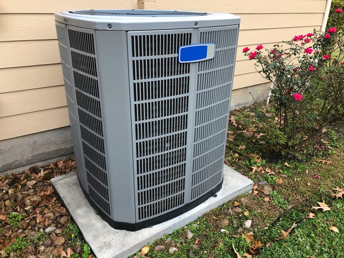 An outdoor HVAC unit outside of a home during the fall