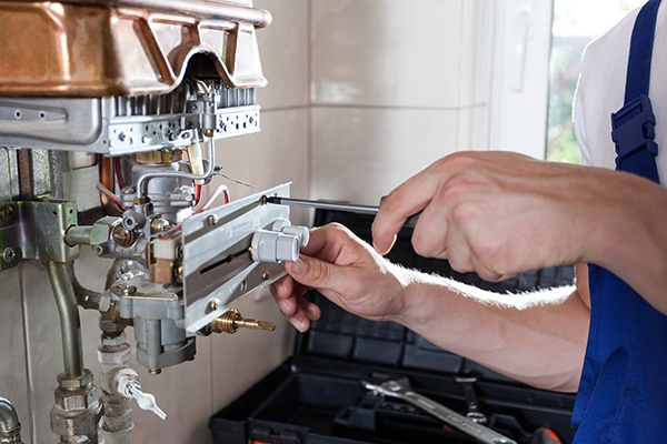 Handyman adjusting gas water heater