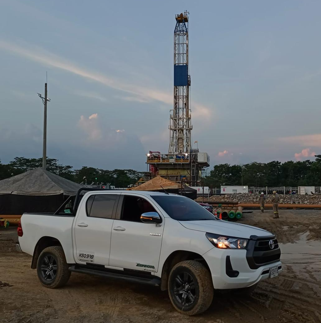 Camioneta pickup Toyota Hilux blanca estacionada en sendero rodeado de vegetación tropical