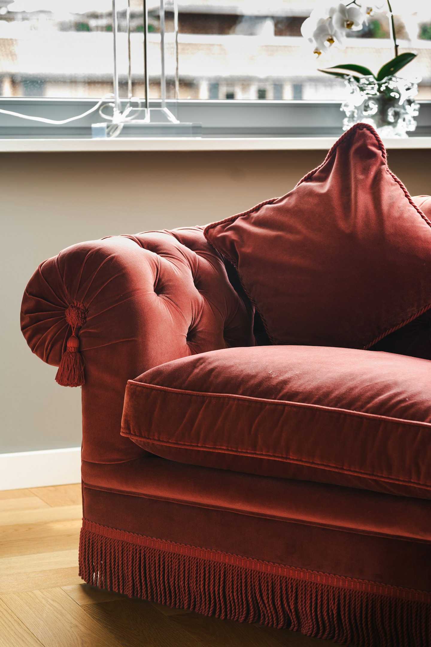 A red couch sitting in front of a window