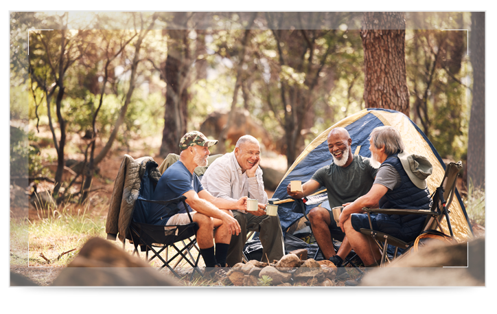 Four seniors outside near camping tents