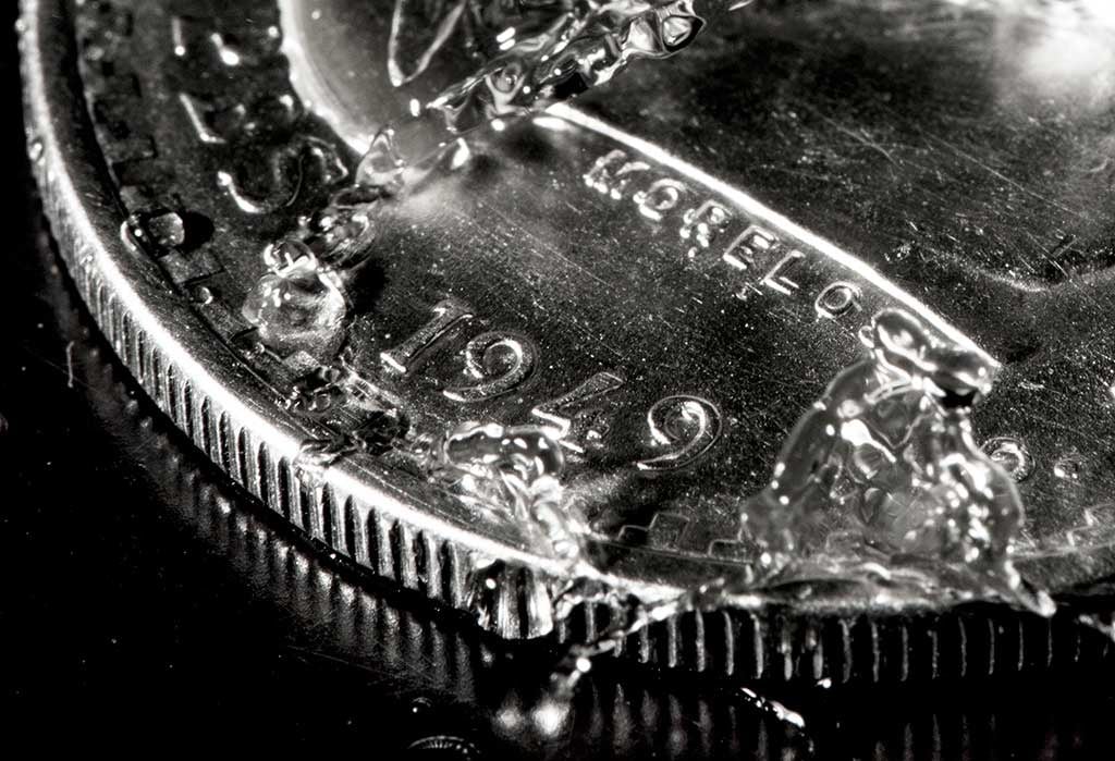 Primer plano de una moneda de 1949 parcialmente cubierta de hielo.