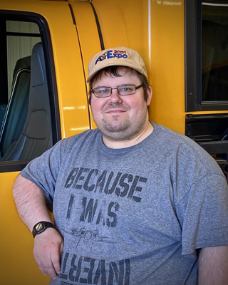 Dan started at our Shakopee yard in January 2022. Currently he’s a Para on a Chaska route.

Dan really likes the environment, as he said it’s very calm compared to his last place of employment. Proof that hanging out with kids does have a calming effect…

When not on the bus, he enjoys video games, reading, building model kits and listening to music!