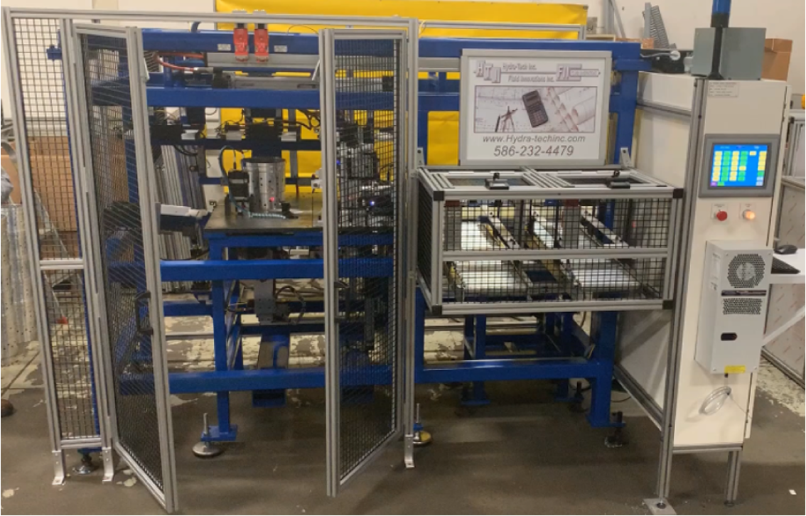 Industrial machine with blue metal frame and control panel for automated manufacturing.