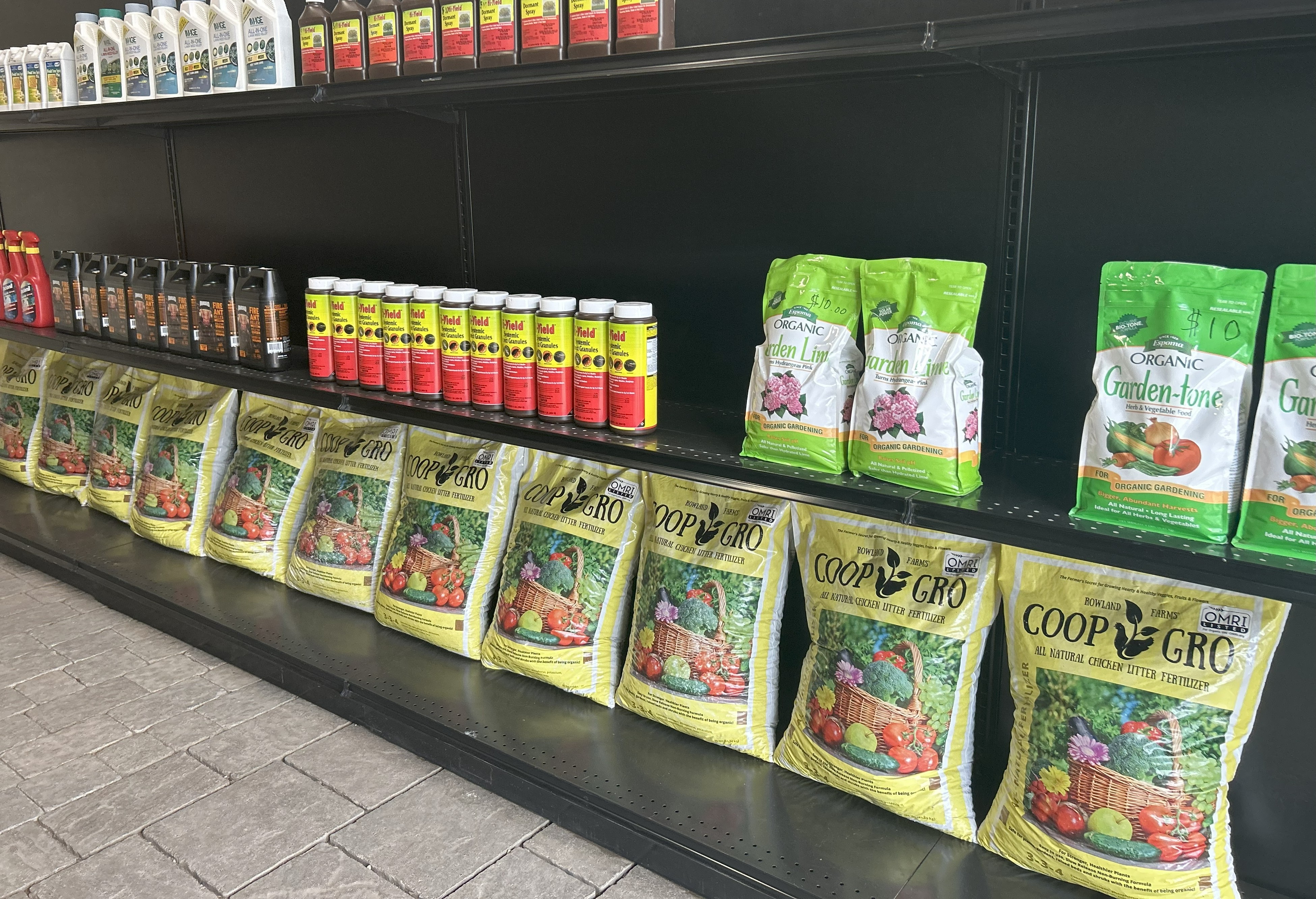 Beautiful landscaped front yard with a stone path, flowering shrubs, and a traditional house in the background.