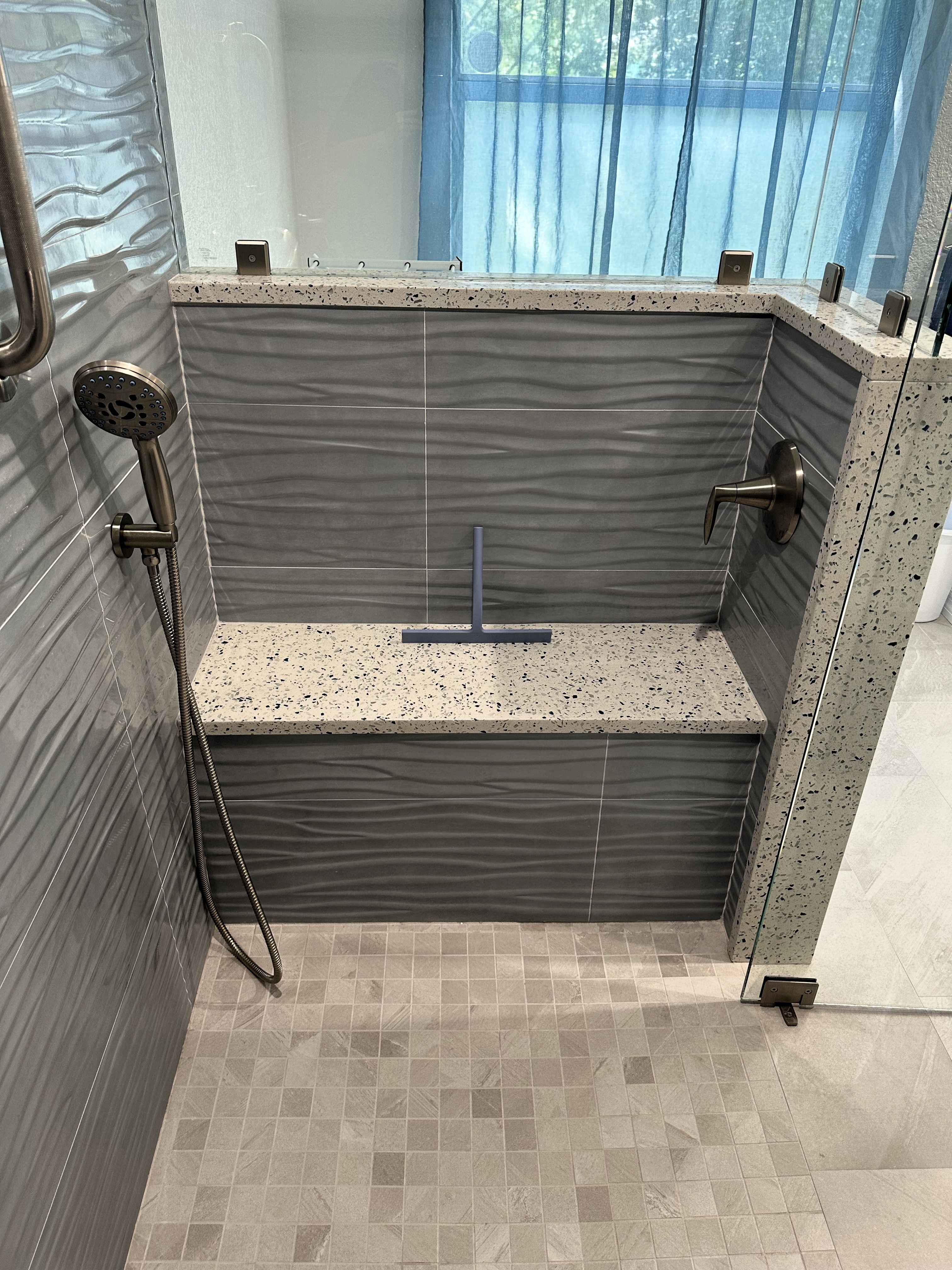 A luxurious shower bench crafted with care and topped with Arctic Recycled Glass Quartz, offering an eco-friendly design paired with a sleek, stunning finish.