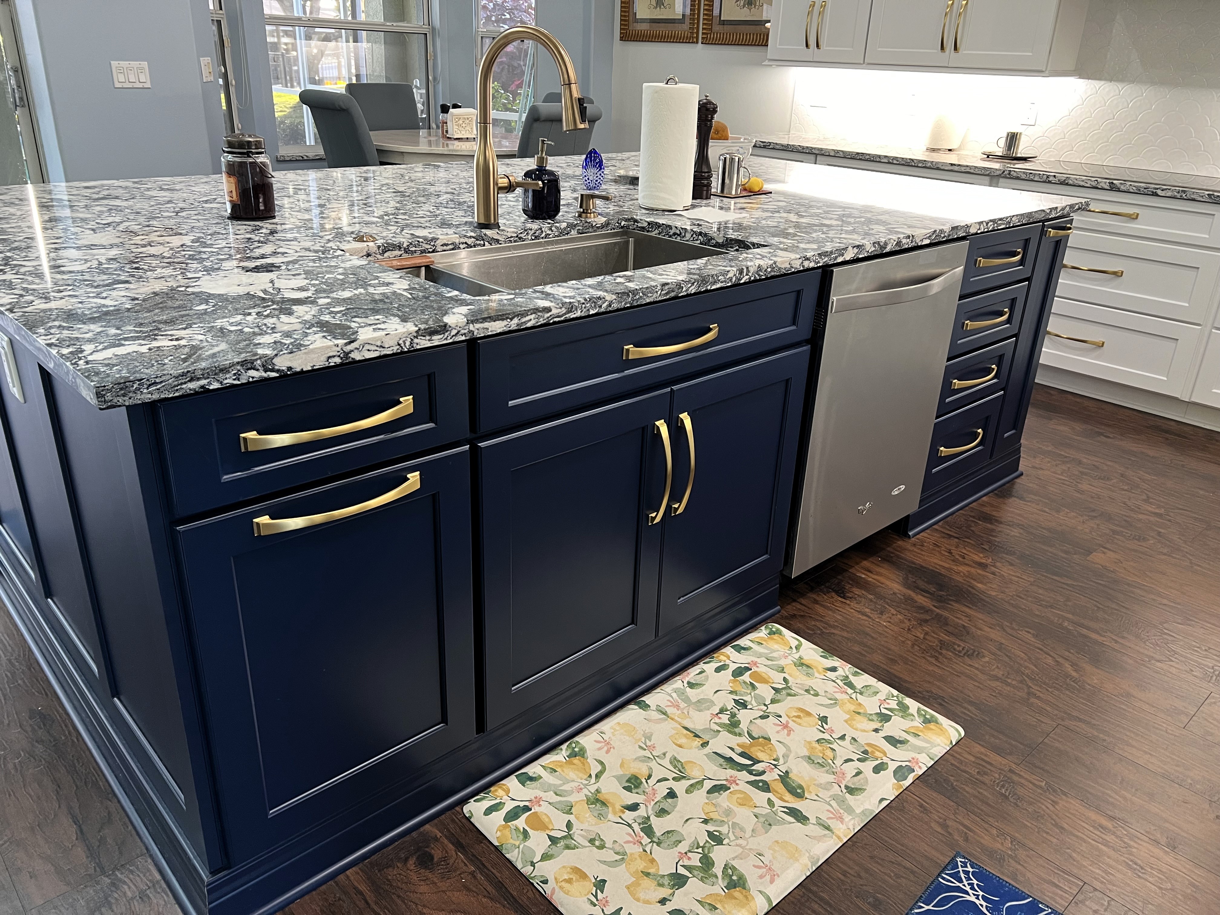 Elegant and functional kitchen island featuring gorgeous Cambria Mayfair quartz, gold hardware, and gold faucet.
