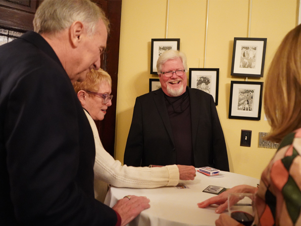 Chuck performing corporate walkaround magic with three participants at a table. Chuck performing corporate walkaround magic with three participants at a table.