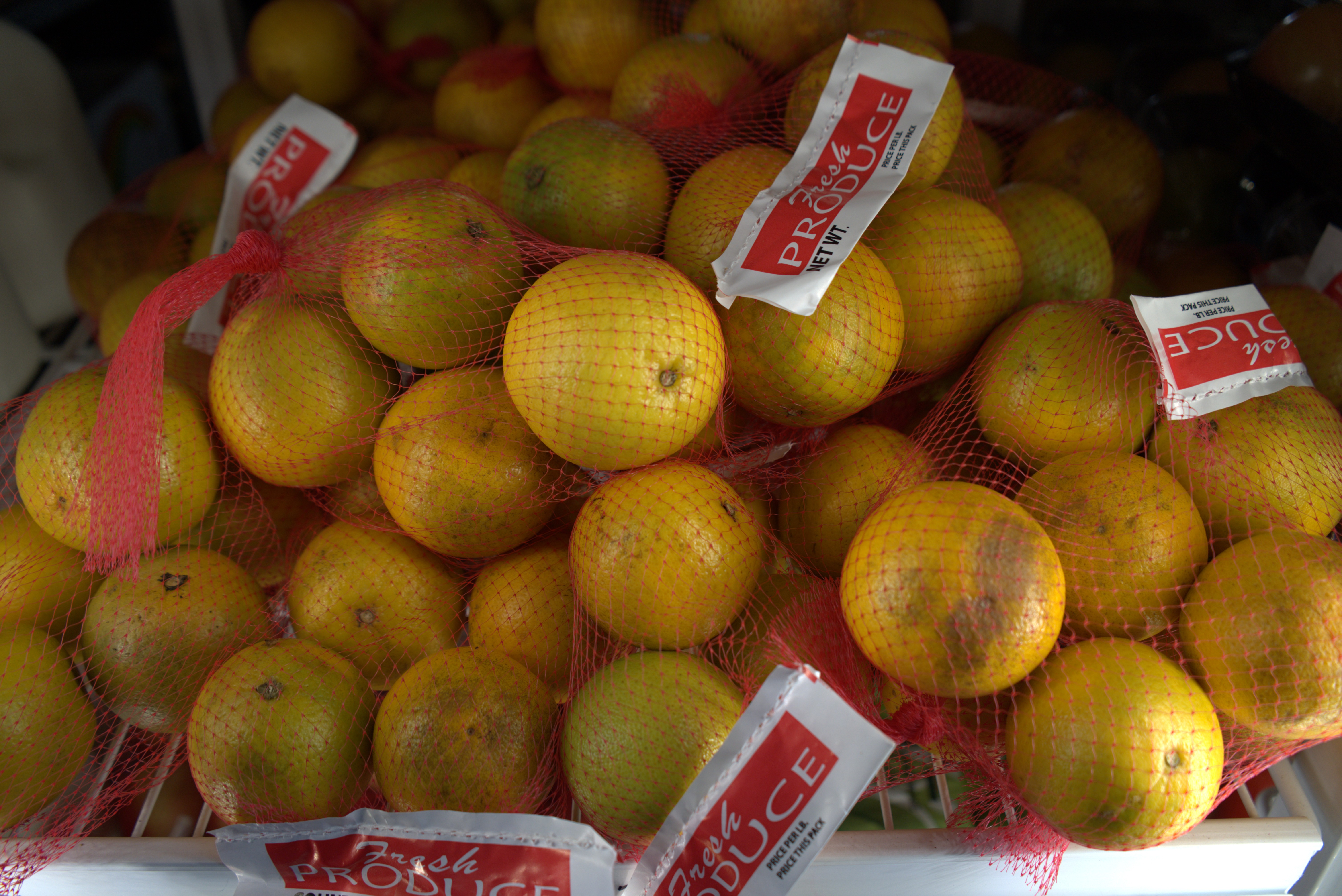 Assorted fresh fruits and vegetables with milk and juice on a grocery store shelf.