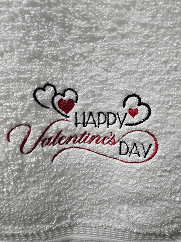 White hand towel with Happy Valentine's day embroidered on it