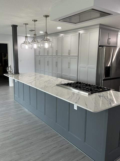 Massive island featuring maple painted Perfect Storm semi-custom cabinetry and tranquil Dekton Trance countertop. 