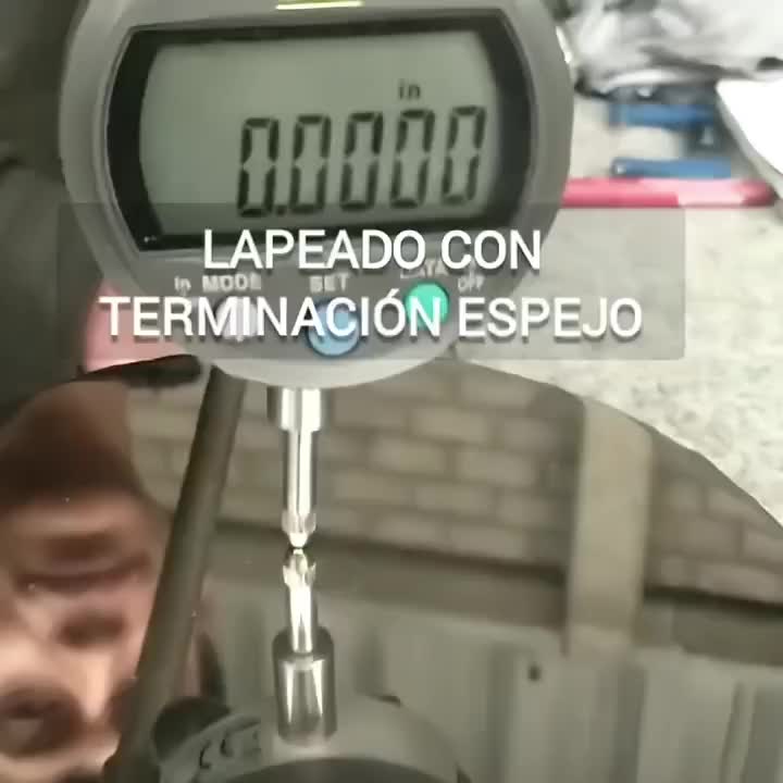 Calibrador digital mostrando 0.0000 pulgadas sobre superficie lapeada con terminación espejo.