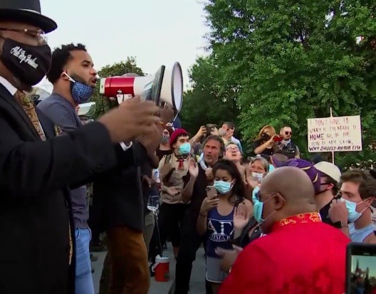 Pastor Green (red clergy robe) attending recent protest