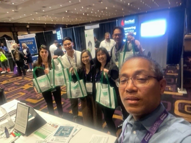 Josh Binarao with attendees and their Calmoseptine tote bags. Western Pharmacy Exchange show in Las Vegas, NV. April 2024.
