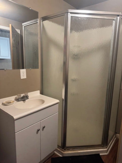 Campground with several RVs parked on paved paths, surrounded by lush green trees and vibrant flower beds under a blue sky.