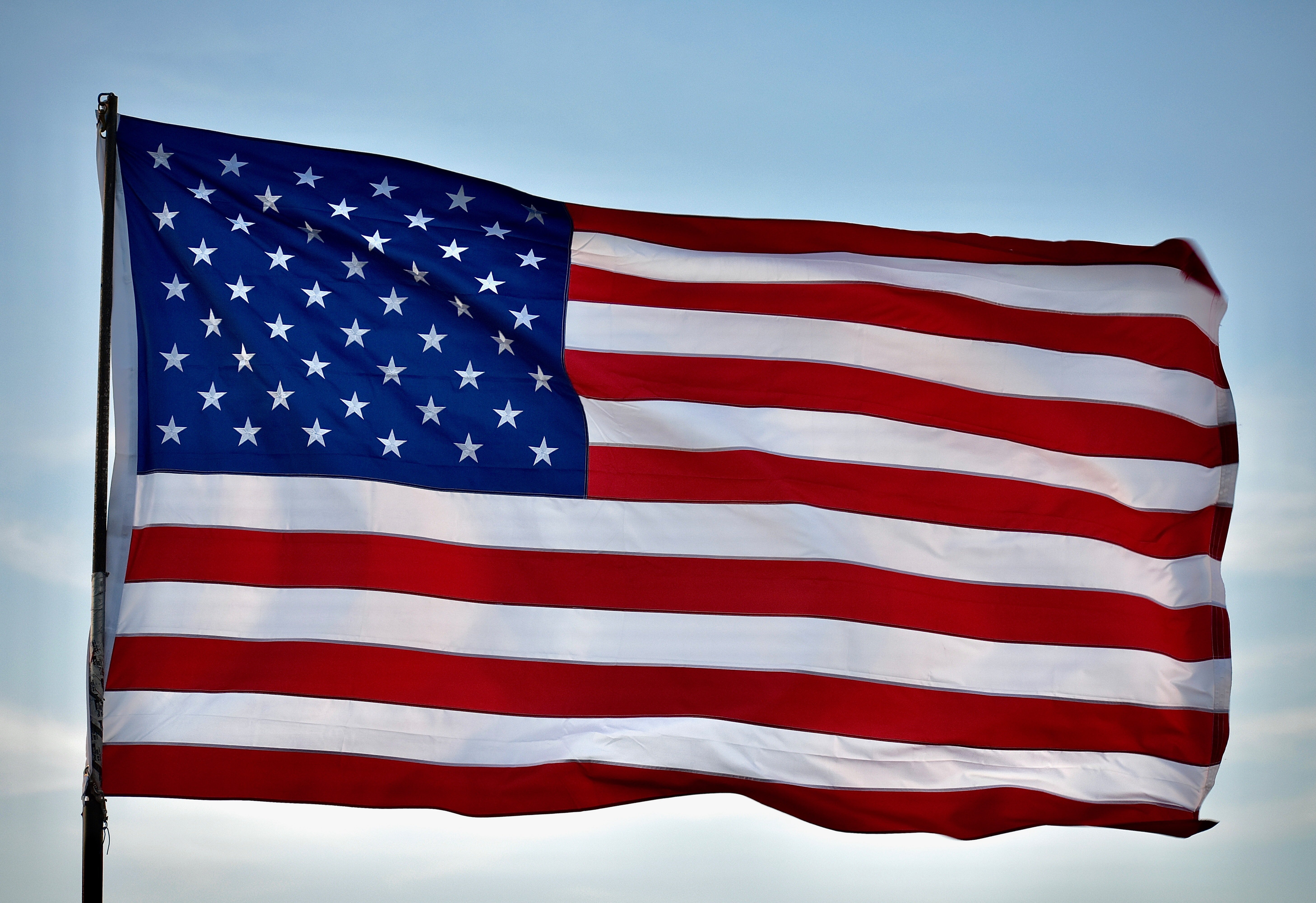American flag waving against a clear blue sky American flag waving against a clear blue sky