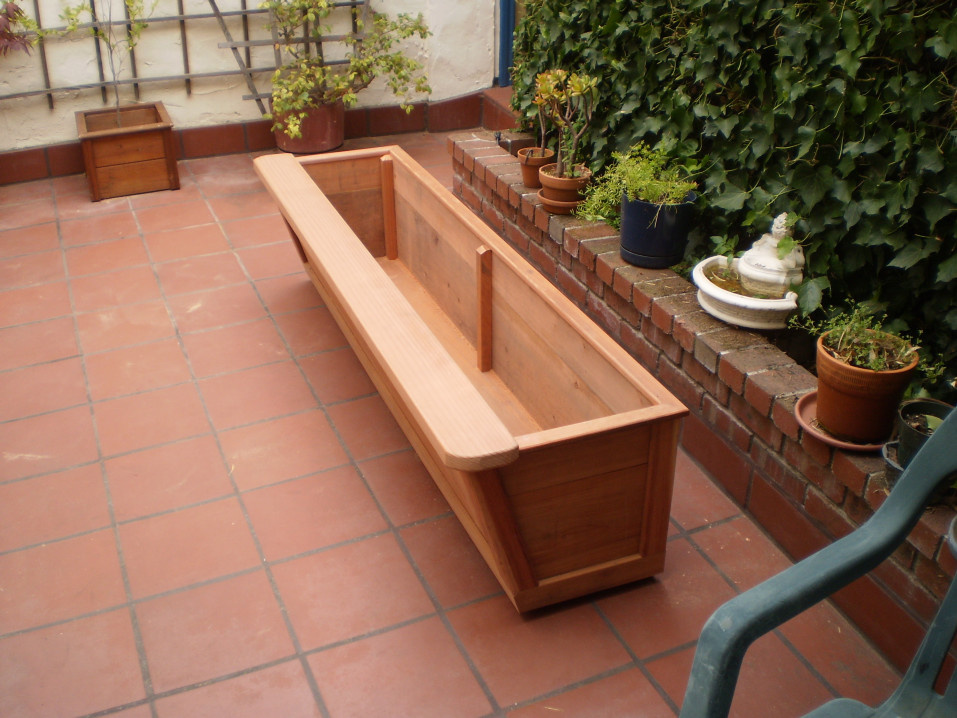 Six foot planter with seating pad inlayed in.