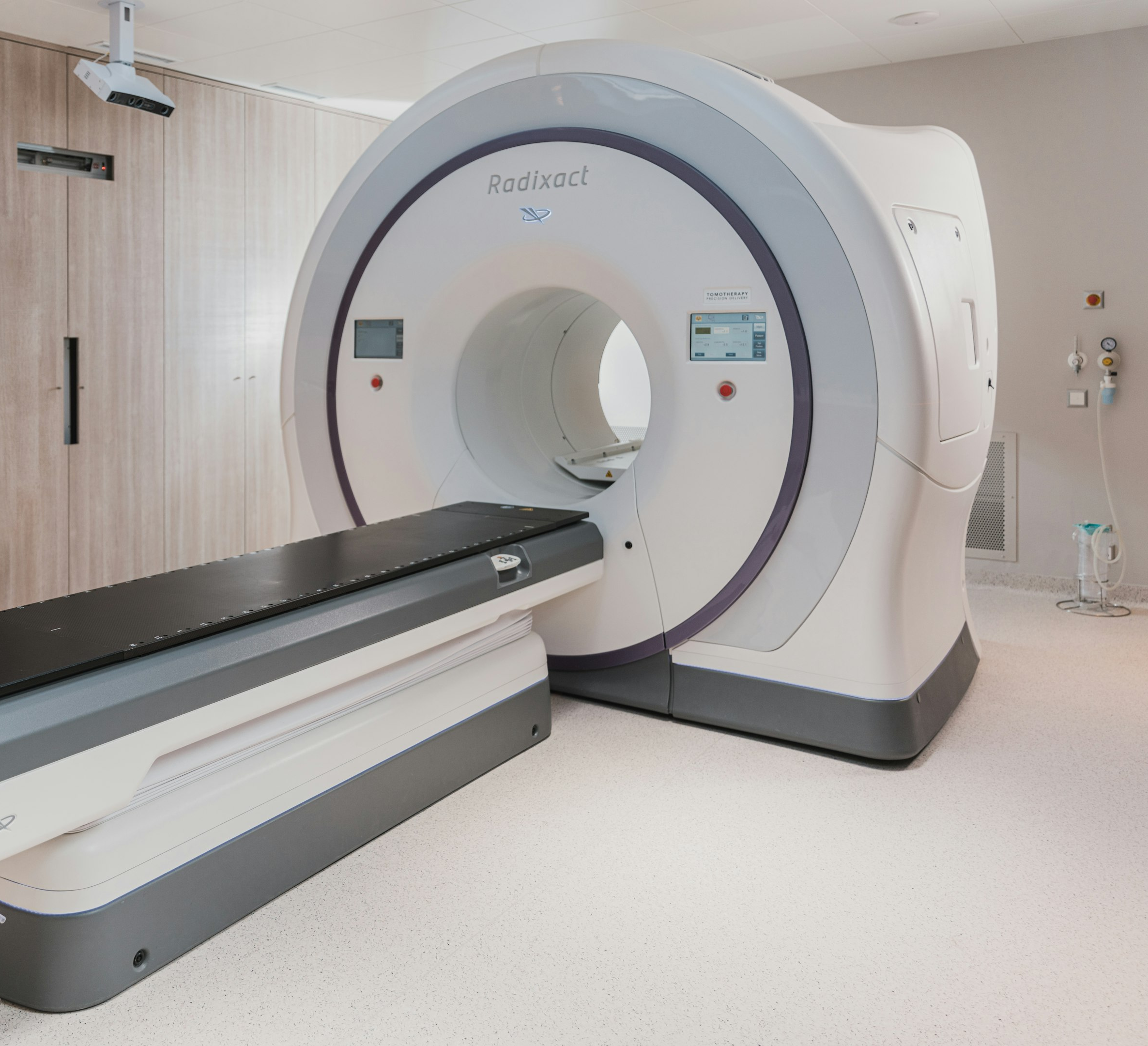 Sala de resonancia magnética moderna con equipos médicos avanzados y decoración en tonos azules.