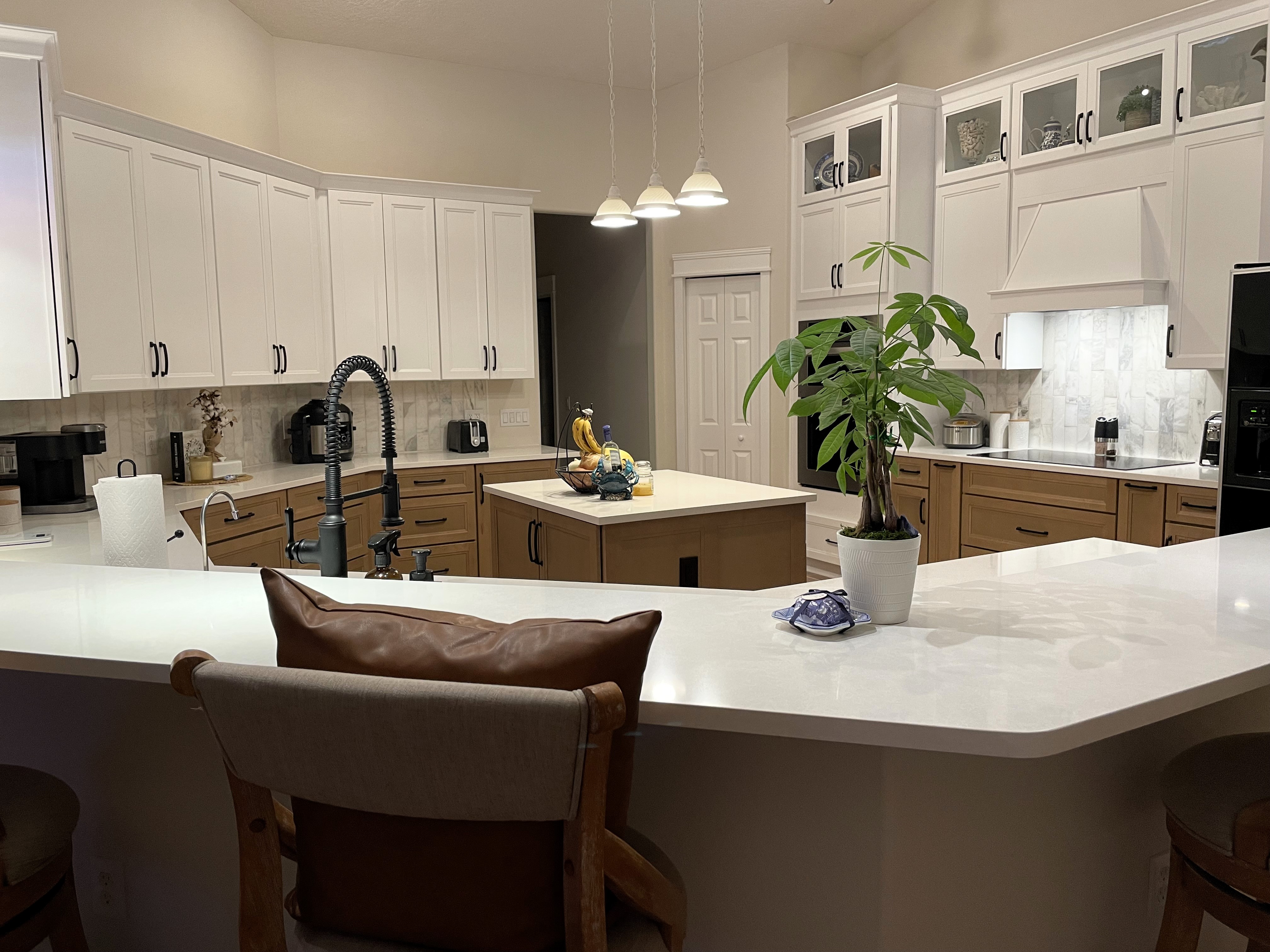 Grand kitchen featuring two-toned semi-custom cabinetry and matte black hardware. 