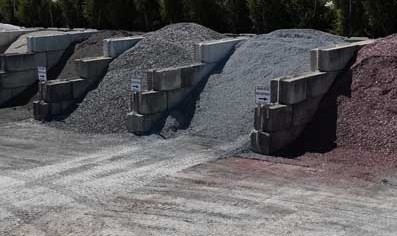 Charming suburban house with a well-maintained garden, colorful flowers, and a winding pathway, surrounded by lush green trees under a clear blue sky.