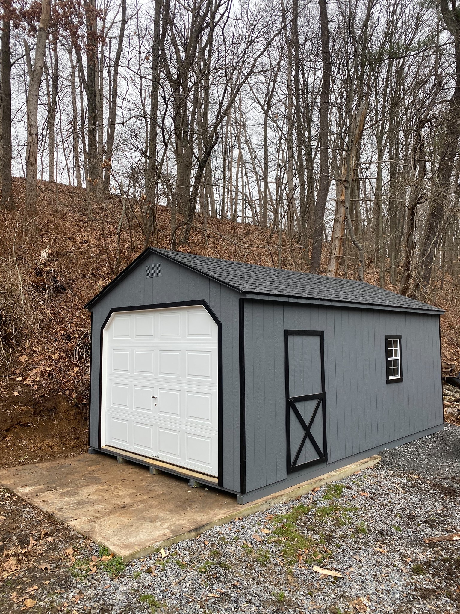 12 x 20 A-Frame Garage                                                 
                                                              Featuring gray colored wood siding, black colored trim, and black colored 30 year architectural shingles (with tarpaper underlayment), gable vents,
2- 18”x27” slider windows with screens and black colored box trim. 1- 9x7 overhead door, 1-3’ entry door, pressure treated floor joists and skids.