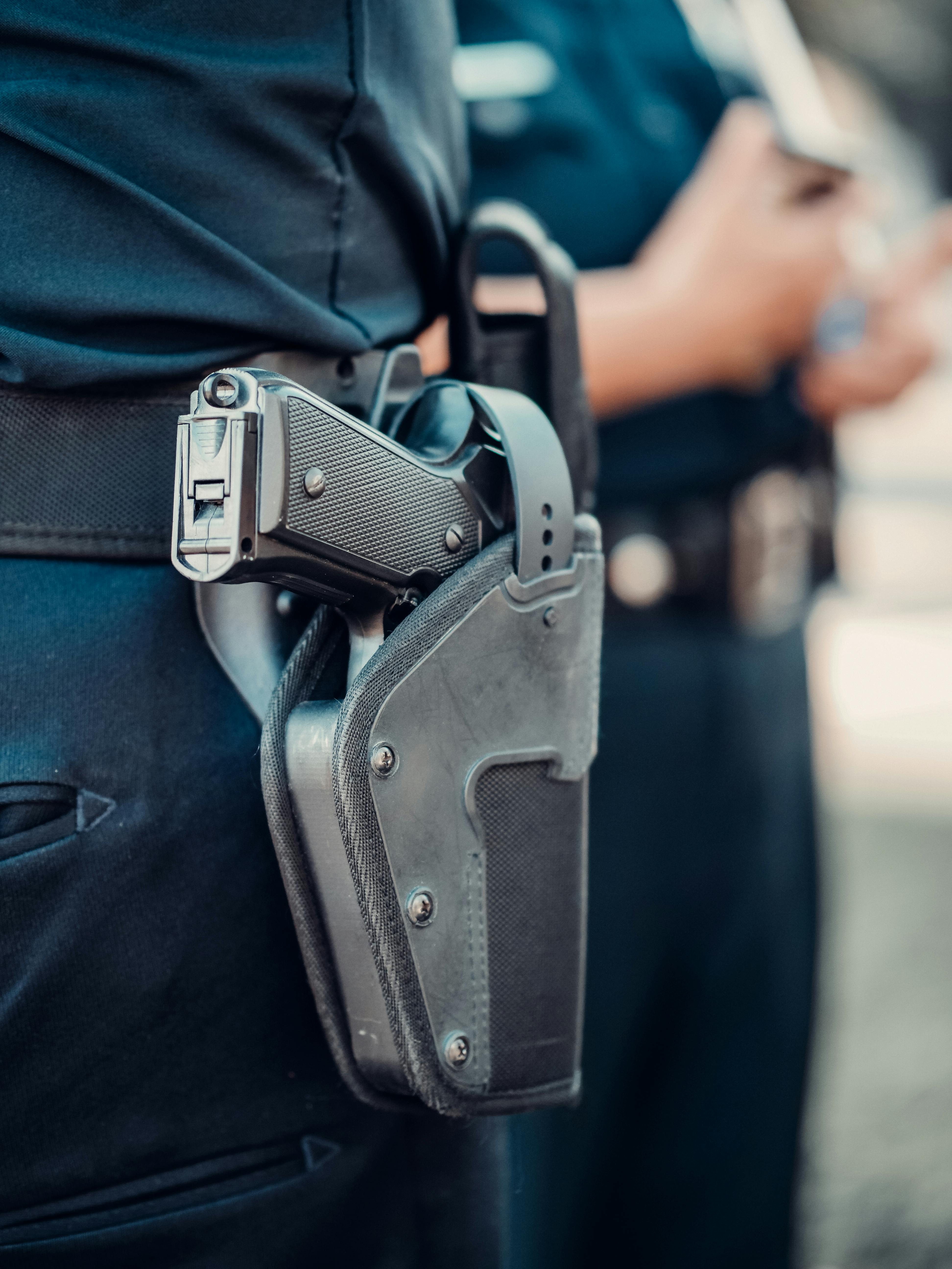 A gun in a holster attached to a person