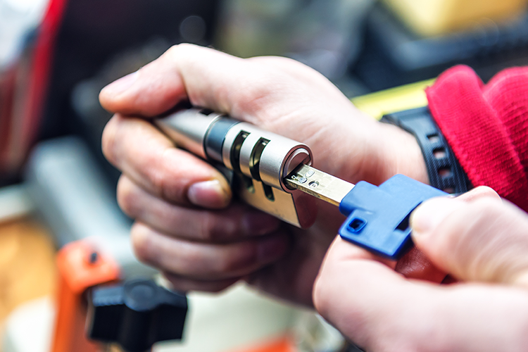 locksmith is testing door lock cylinder