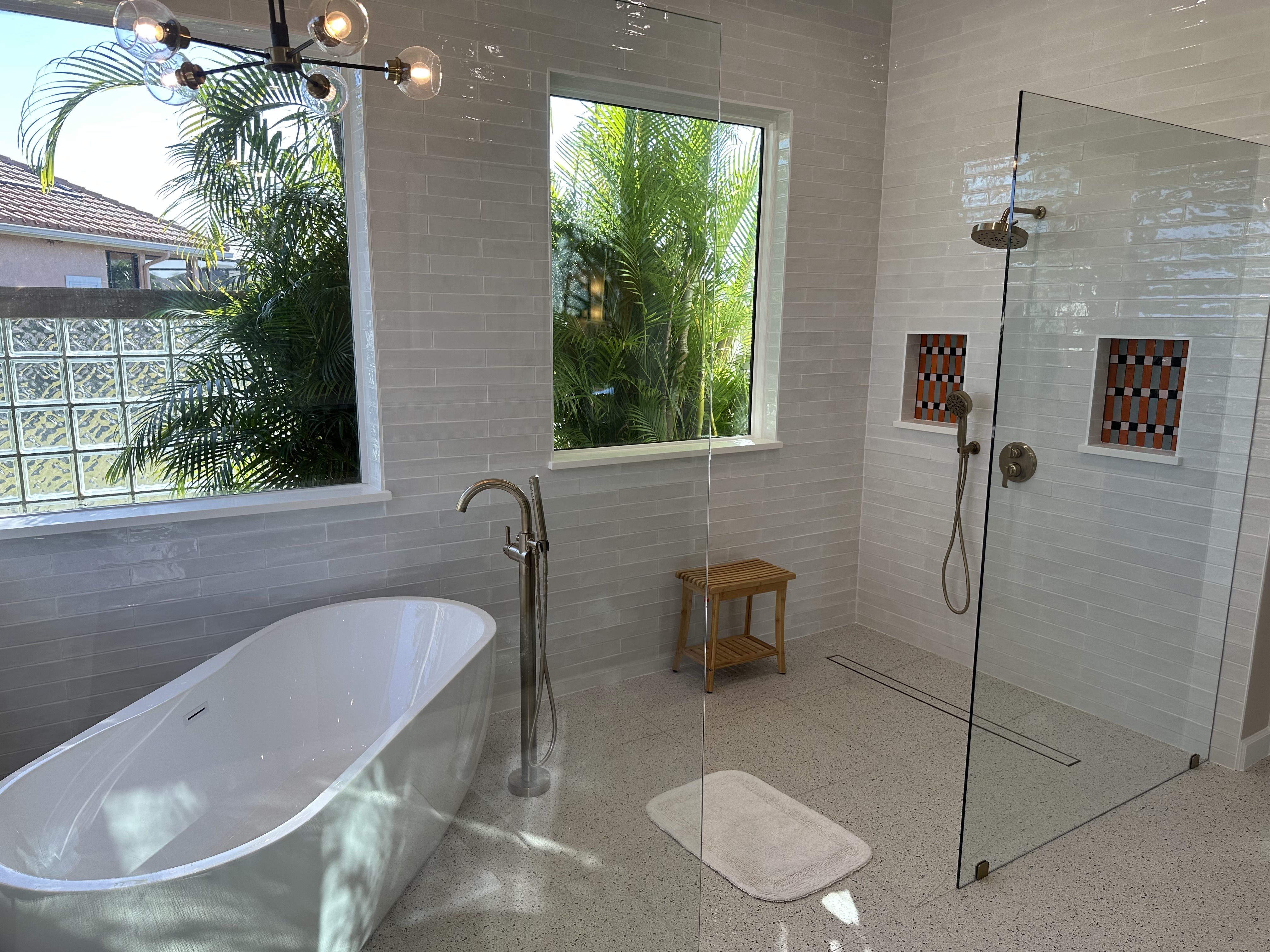 An expansive walk-in shower with thoughtfully designed niches for bath products and a modern linear drain integrated flawlessly into the shower floor.