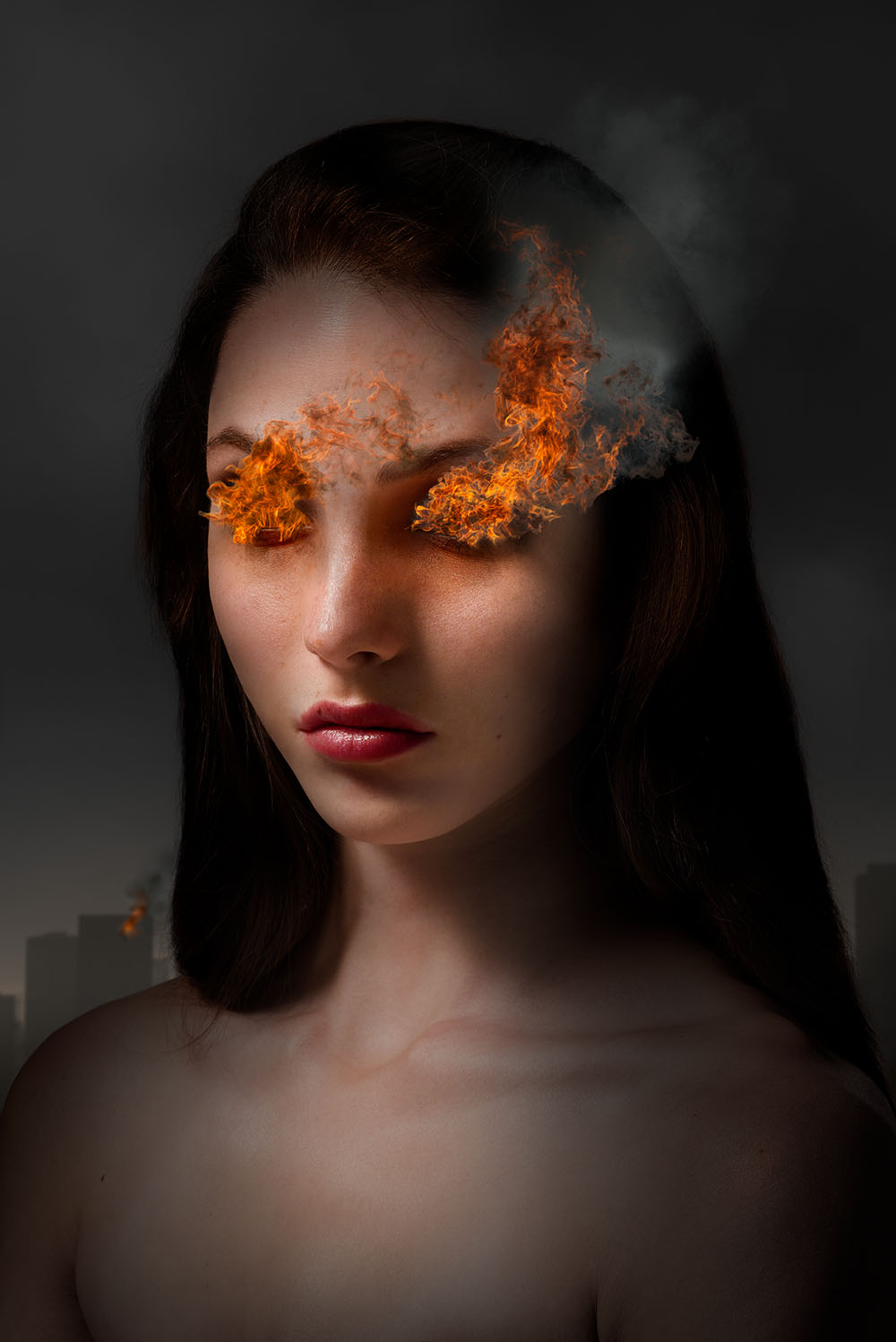 Dark, dramatically lit portrait of woman with flames and smoke coming from her eyes, with a burning building in background.  