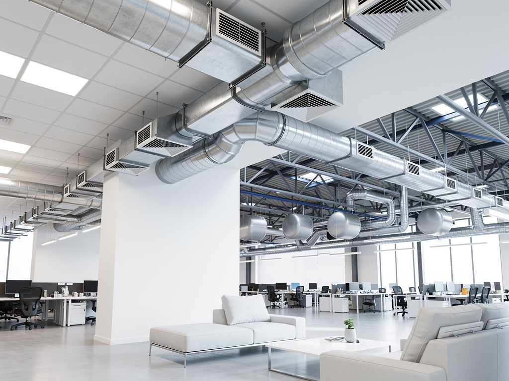Oficina moderna de planta abierta con conductos de ventilación HVAC expuestos en el techo