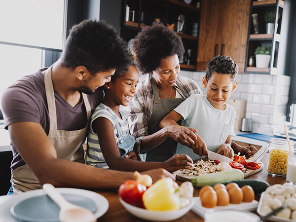 Family Preparing Healthy Food Together In Kitchen