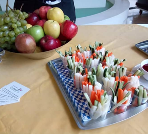 Young boy eating a slice of watermelon with a playful expression, against a brick wall background.
